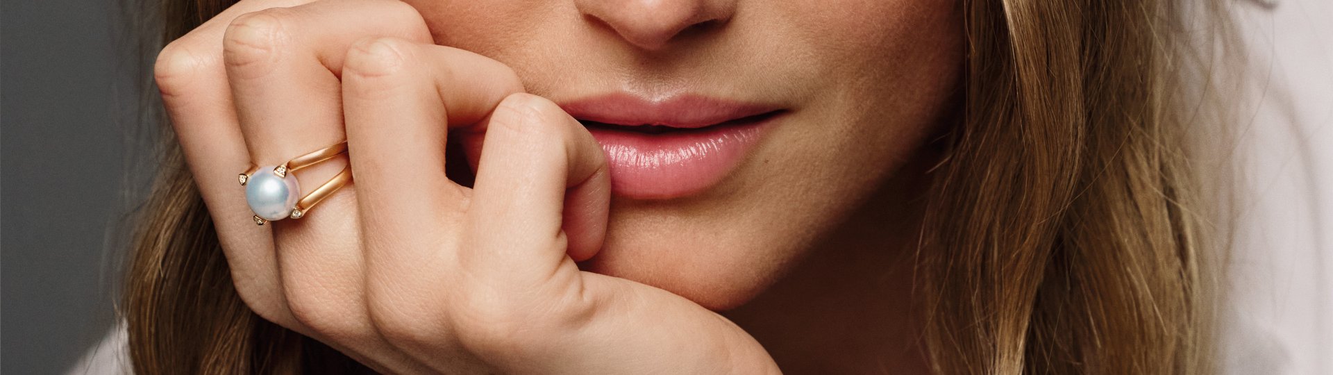 Model trägt einen Gellner Ring aus Roségold mit weißer Perle und Diamanten.