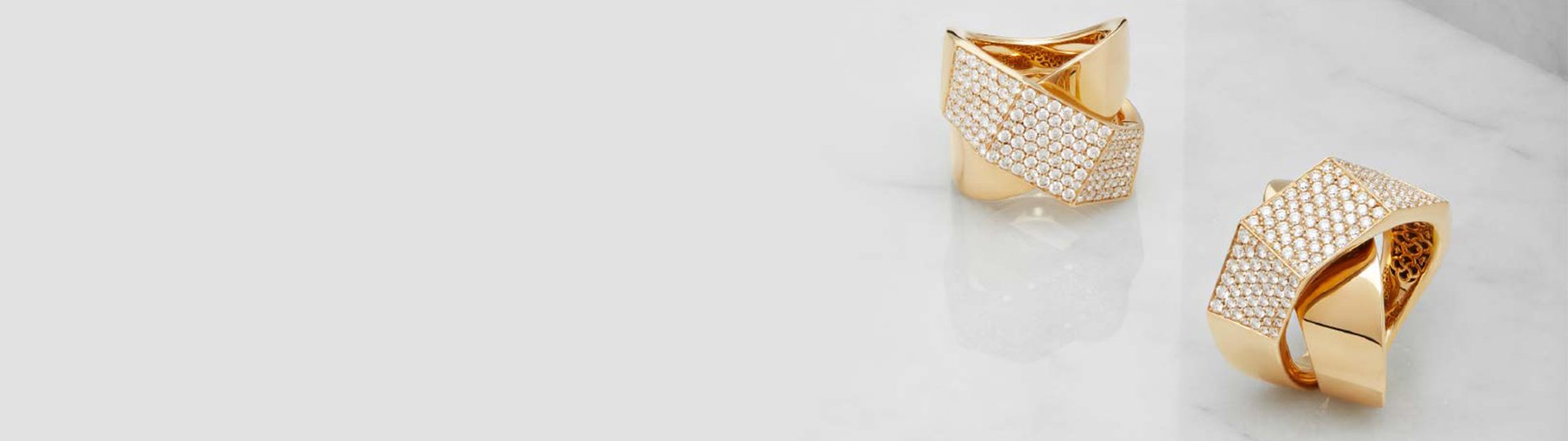 Geometrische Ringe aus Roségold aus der Brave Kollektion von Crivelli mit pavégefassten Diamanten, modern inszeniert auf hellem Marmorhintergrund