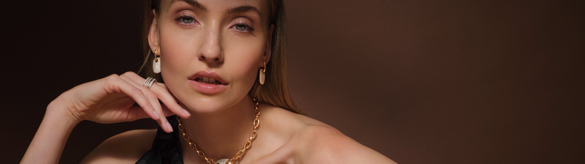 Model mit goldener Gliederkette und diamantbesetztem Anhänger, passenden Ohrringen und Ringen aus dem Atelier Mühlbacher und von Crivelli.