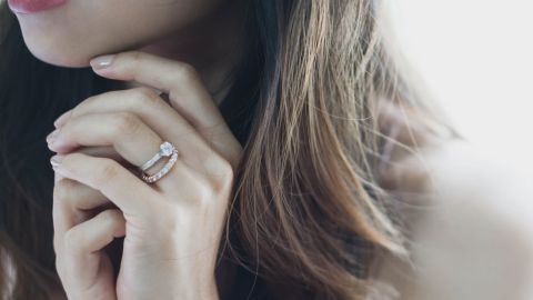 Memoirering in Rosegold komplett mit Diamanten besetzt und Verlobungsring in Weissgold mit einem Diamanten getragen an einer Damenhand Memoirering in Rosegold komplett mit Diamanten besetzt und Verlobungsring in Weissgold mit einem Diamanten getragen an einer Damenhand