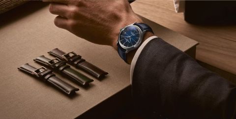 Clifton Baumatic Herrenuhr in Stahl mit blauem Zifferblatt und Lederarmband getragen an einem Herrenhandgelenk, drei Lederarmbaender zu Austauschen liegen daneben Clifton Baumatic Herrenuhr in Stahl mit blauem Zifferblatt und Lederarmband getragen an einem Herrenhandgelenk, drei Lederarmbaender zu Austauschen liegen daneben