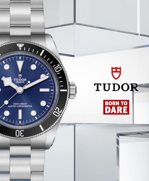 Links Tudor Black Bay 68 Uhr in Stahl mit schwarzer Luenette und blauem Zifferblatt, rechts daneben TUDOR Logo und Born to dare Icon vor blau-grauem Lifestylehintergrund