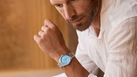 Mann im weißen Hemd trägt eine Clifton von Baume & Mercier mit Edelstahlarmband und eisblauem Zifferblatt. Mann im weißen Hemd trägt eine Clifton von Baume & Mercier mit Edelstahlarmband und eisblauem Zifferblatt.