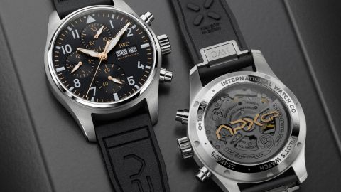 IWC Pilots Watch liegend von vorne und liegend von hinten auf grauem Hintergrund