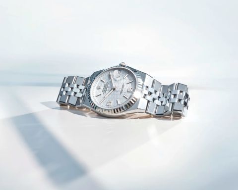 Rolex Land-Dweller Armbanduhr aus Edelstahl mit Jubilee-Armband und silberfarbenem Zifferblatt, liegend auf hellem, minimalistischem Untergrund.