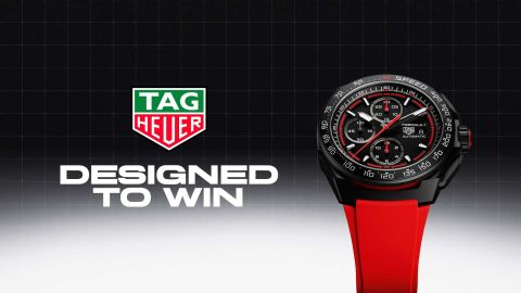 TAG Heuer Logo mit Designed to win Schriftzug, rechts daneben ein TAG Heuer Formula 1 Chronograph mit schwarzem Gehaeuse, schwarzem Zifferblatt und rotem Kautschukband