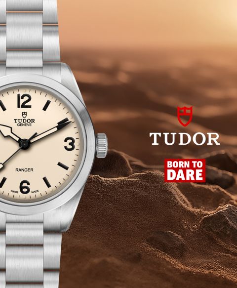 Teilansicht der TUDOR Ranger mit Zifferblatt in „Dust“ vor sandiger Felslandschaft, ergänzt durch TUDOR Logo und „Born To Dare“-Slogan.