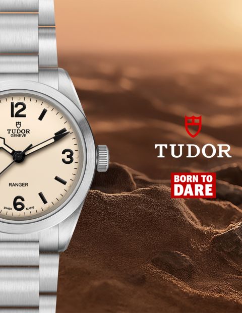 Teilansicht der TUDOR Ranger mit Zifferblatt in &bdquo;Dust&ldquo; vor sandiger Felslandschaft, erg&auml;nzt durch TUDOR Logo und &bdquo;Born To Dare&ldquo;-Slogan.