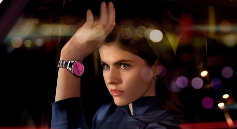 Weibliches Model im Sportwagen sitzend mit Carrera Date in Stahl mit pinkem Zifferblatt am Handgelenk Weibliches Model im Sportwagen sitzend mit Carrera Date in Stahl mit pinkem Zifferblatt am Handgelenk