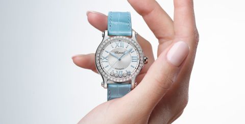 Chopard Happy Sport Damenuhr mit Gehaeuse in Stahl mit Diamantluenette, silbernem Zifferblatt mit 5 beweglichen Diamanten und hellblauem Lederarmband stehend auf einer Hand Chopard Happy Sport Damenuhr mit Gehaeuse in Stahl mit Diamantluenette, silbernem Zifferblatt mit 5 beweglichen Diamanten und hellblauem Lederarmband stehend auf einer Hand