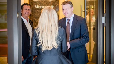 Die Geschaeftsfuehrer Andreas und Markus Muehlbacher begruessen an der Eingangstuer zum Juweliergeschaeft eine neue Mitarbeiterin