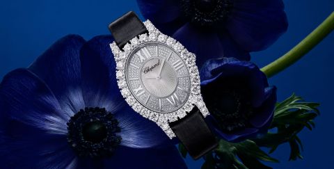 Chopard L'Heure du Diamant Damenuhr mit Gehaeuse in Weissgold besetzt mit Diamanten, silbernem Zifferblatt mit roemischen Ziffern und schwarzem Textilarmband vor blauem Hintergrund Chopard L'Heure du Diamant Damenuhr mit Gehaeuse in Weissgold besetzt mit Diamanten, silbernem Zifferblatt mit roemischen Ziffern und schwarzem Textilarmband vor blauem Hintergrund