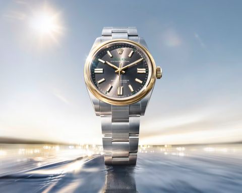 Rolex Oyster Perpetual Armbanduhr in Edelstahl und Gold mit grauem Zifferblatt vor dynamischem, lichtdurchflutetem Hintergrund
