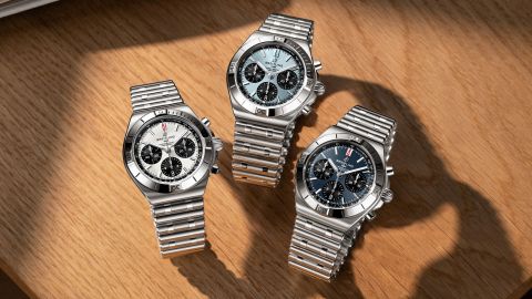 Drei Breitling Chronomat B01 42 Chronographen mit wei&szlig;en, eisblauen und dunkelblauen Zifferbl&auml;ttern auf heller Holzoberfl&auml;che.