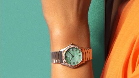 Ebel-Uhr mit silbernem Gehäuse und Armband, gelbgoldener Diamantlünette, grünem Zifferblatt, römischen Ziffern und Diamantindizes, präsentiert an einem Handgelenk Ebel-Uhr mit silbernem Gehäuse und Armband, gelbgoldener Diamantlünette, grünem Zifferblatt, römischen Ziffern und Diamantindizes, präsentiert an einem Handgelenk