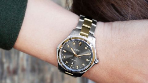 Ebel Discovery Uhr mit Stahlgehaeuse und Gelbgoldluenette, anthrazitgraues Zifferblatt mit Diamantindizes und Bicolor-Armband in Stahl und Gelbgold getragen am Handgelenk Ebel Discovery Uhr mit Stahlgehaeuse und Gelbgoldluenette, anthrazitgraues Zifferblatt mit Diamantindizes und Bicolor-Armband in Stahl und Gelbgold getragen am Handgelenk