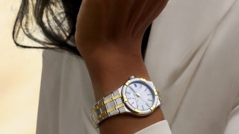 Maurice Lacroix Aikon Uhr mit Gehaeuse und Armband in Stahl und Gelbgold mit grausilbernem Zifferblatt an weiblichem Handgelenk Maurice Lacroix Aikon Uhr mit Gehaeuse und Armband in Stahl und Gelbgold mit grausilbernem Zifferblatt an weiblichem Handgelenk