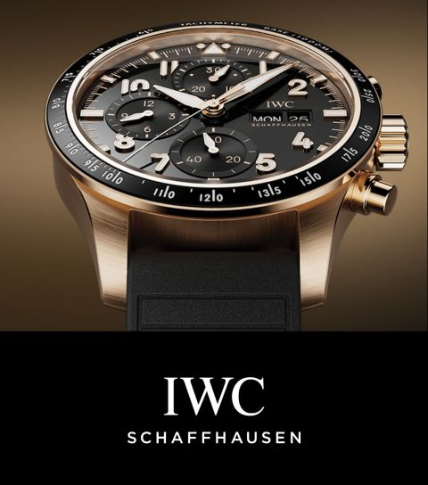 IWC Pilots Watch in Gold mit schwarzer Luenette, schwarzem Zifferblatt und Kautschukarmband, darunter IWC Logo