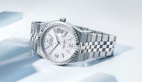 Rolex Land-Dweller Armbanduhr aus Edelstahl mit silbernem Jubilé-Armband und hellem strukturiertem Zifferblatt auf hellem Hintergrund inszeniert.