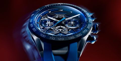 Gehaeuse einer TAG Heuer Carrera Chronograph in Titan mit blauer Luenette und skelettiertem Zifferblatt vor dunkelrotem Hintergrund Gehaeuse einer TAG Heuer Carrera Chronograph in Titan mit blauer Luenette und skelettiertem Zifferblatt vor dunkelrotem Hintergrund