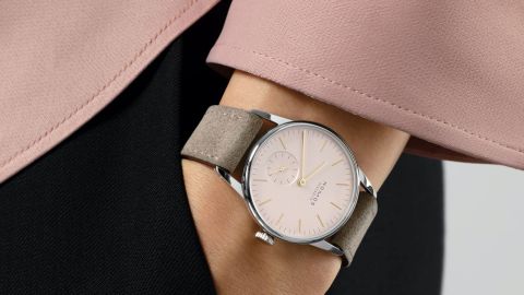 Weibliches Model mit NOMOS Glashuette Uhr in Stahl mit rosefarbenem Zifferblatt und Lederarmband am Handgelenk Weibliches Model mit NOMOS Glashuette Uhr in Stahl mit rosefarbenem Zifferblatt und Lederarmband am Handgelenk