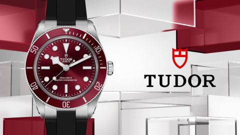 Links Tudor Black Bay 54 Uhr in Stahl mit roter Luenette und Zifferblatt, rechts daneben TUDOR Logo vor rot-grauem Lifestylehintergrund